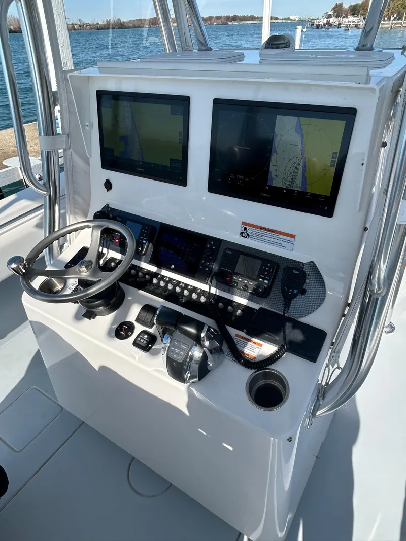 Slide: The Image of 2022 Contender 35 ST boat dashboard with dual navigation screens and steering wheel. - 25