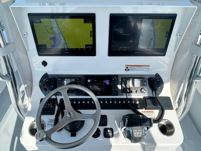 Slide: The Image of 2022 Contender 35 ST boat dashboard with dual navigation screens and steering wheel. - 27