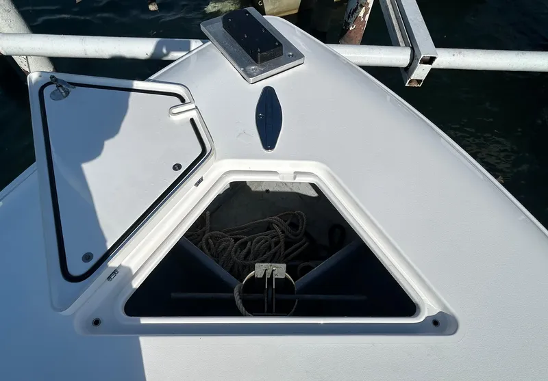 Slide: The Image of 2022 Contender 35 ST boat anchor compartment with open hatch, docked by the water. - 44