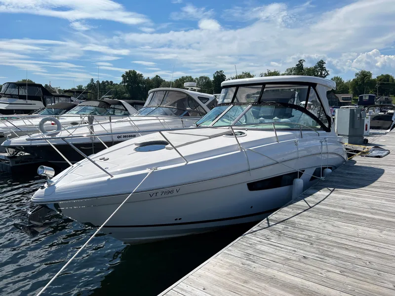 The Image of 2021 Regal 33 Express boat docked at marina under clear sky. - 0