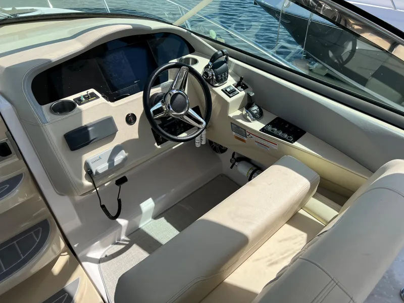 Slide: The Image of 2021 Regal 33 Express boat cockpit with steering wheel and navigation controls. - 10