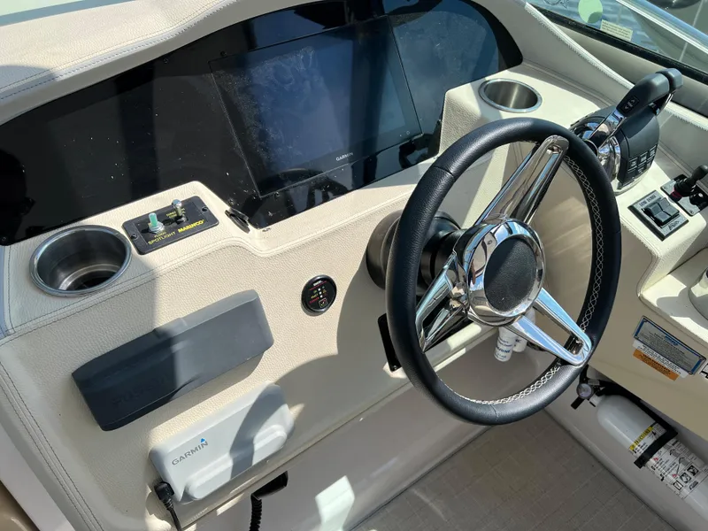 Slide: The Image of 2021 Regal 33 Express helm with steering wheel, control panel, and cup holders. - 12