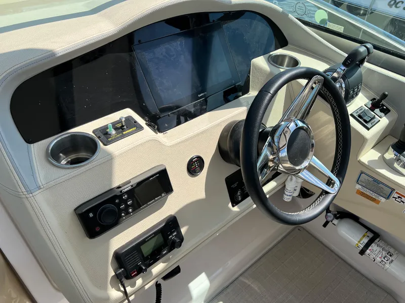Slide: The Image of 2021 Regal 33 Express helm with steering wheel, controls, and navigation equipment. - 13