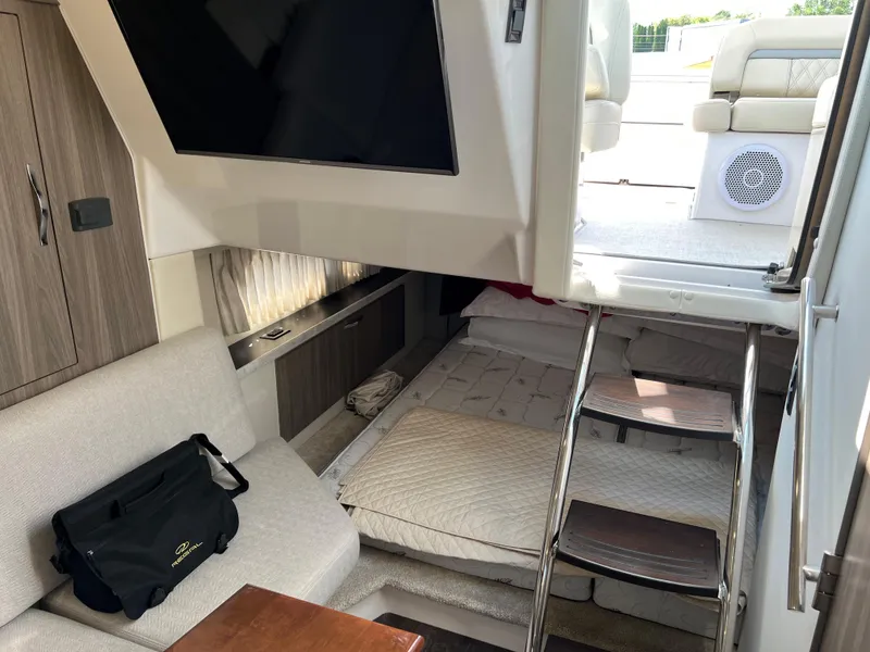 Slide: The Image of Interior of 2021 Regal 33 Express yacht with seating, bed, and stairs to deck. - 15