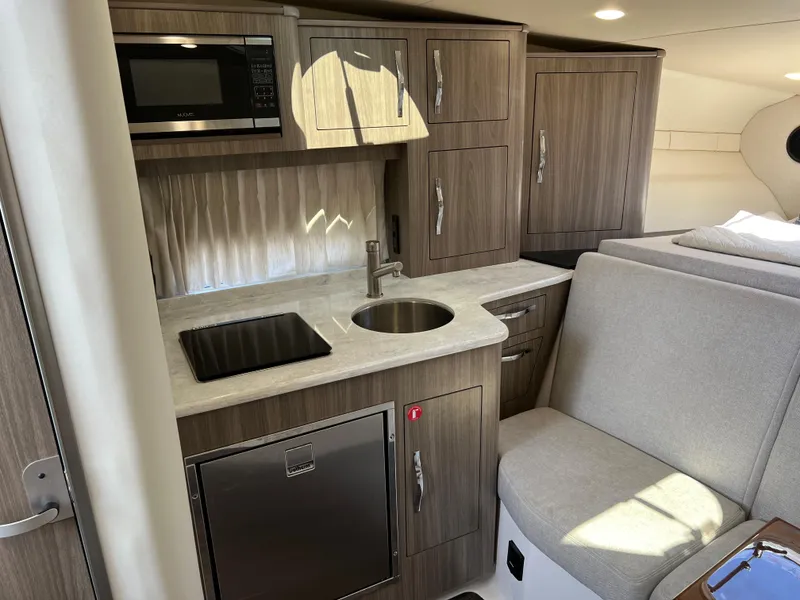 Slide: The Image of Modern kitchen interior of 2021 Regal 33 Express yacht with wood cabinets and appliances. - 17