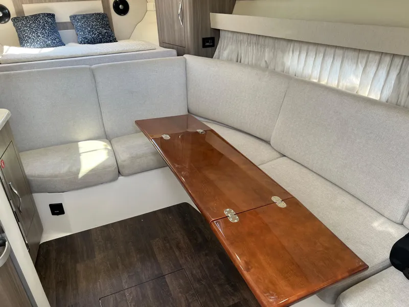 Slide: The Image of 2021 Regal 33 Express interior with cozy seating and wooden table. - 18