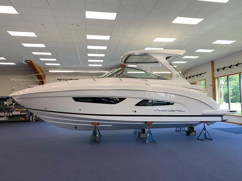 Slide: The Image of 2021 Regal 33 Express boat displayed indoors on stands. - 22