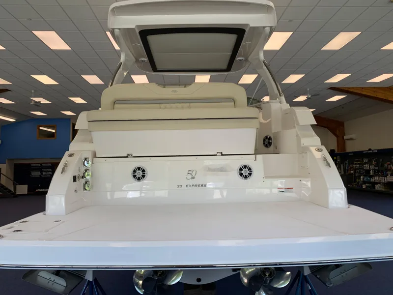 Slide: The Image of 2021 Regal 33 Express boat interior with seating and speakers in showroom. - 25