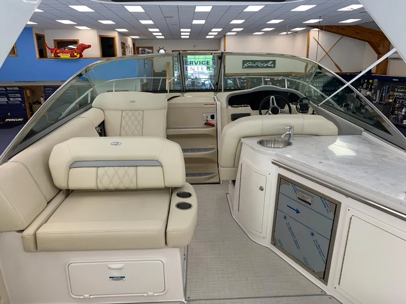 Slide: The Image of 2021 Regal 33 Express boat interior with seating, helm, and kitchenette. - 26