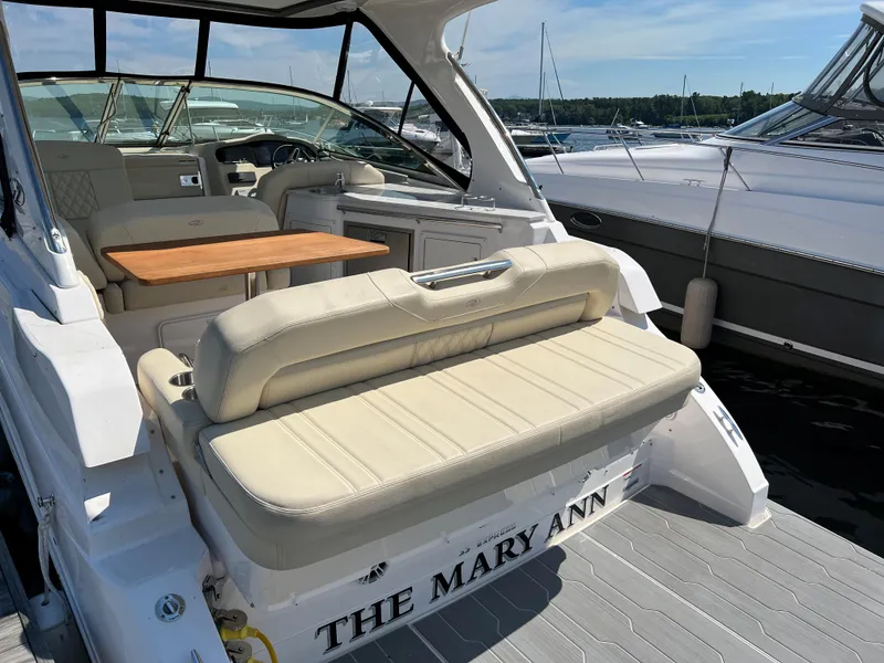 Slide: The Image of 2021 Regal 33 Express boat with beige seating and wooden table, docked at a marina. - 3