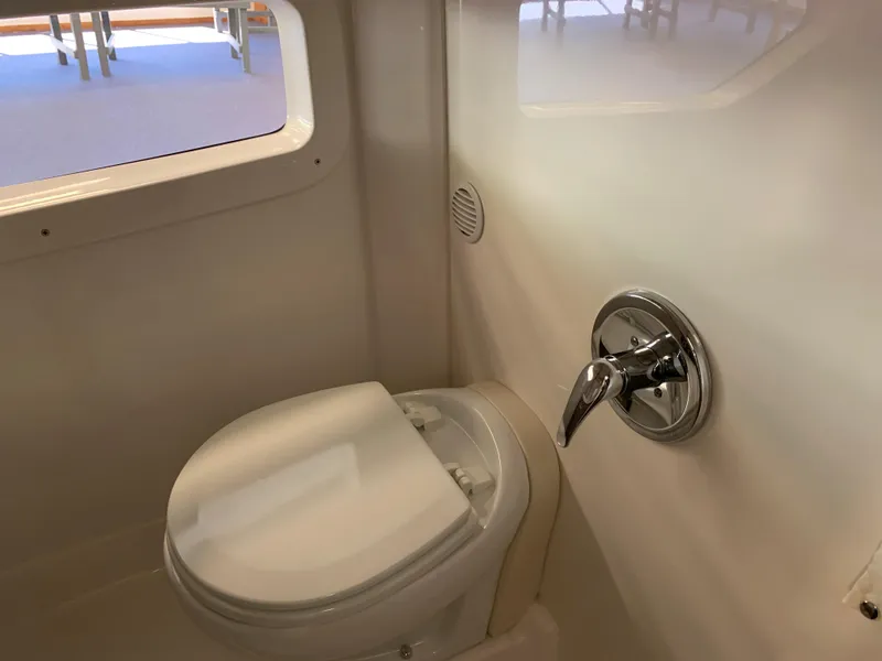 Slide: The Image of 2021 Regal 33 Express boat bathroom with toilet and window. - 46