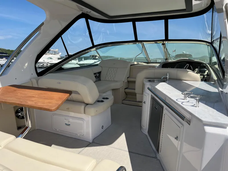 Slide: The Image of 2021 Regal 33 Express boat interior with seating, kitchenette, and wooden table. - 5