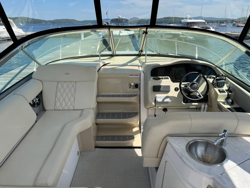 Slide: The Image of 2021 Regal 33 Express boat interior with helm, seating, and sink, docked at marina. - 8