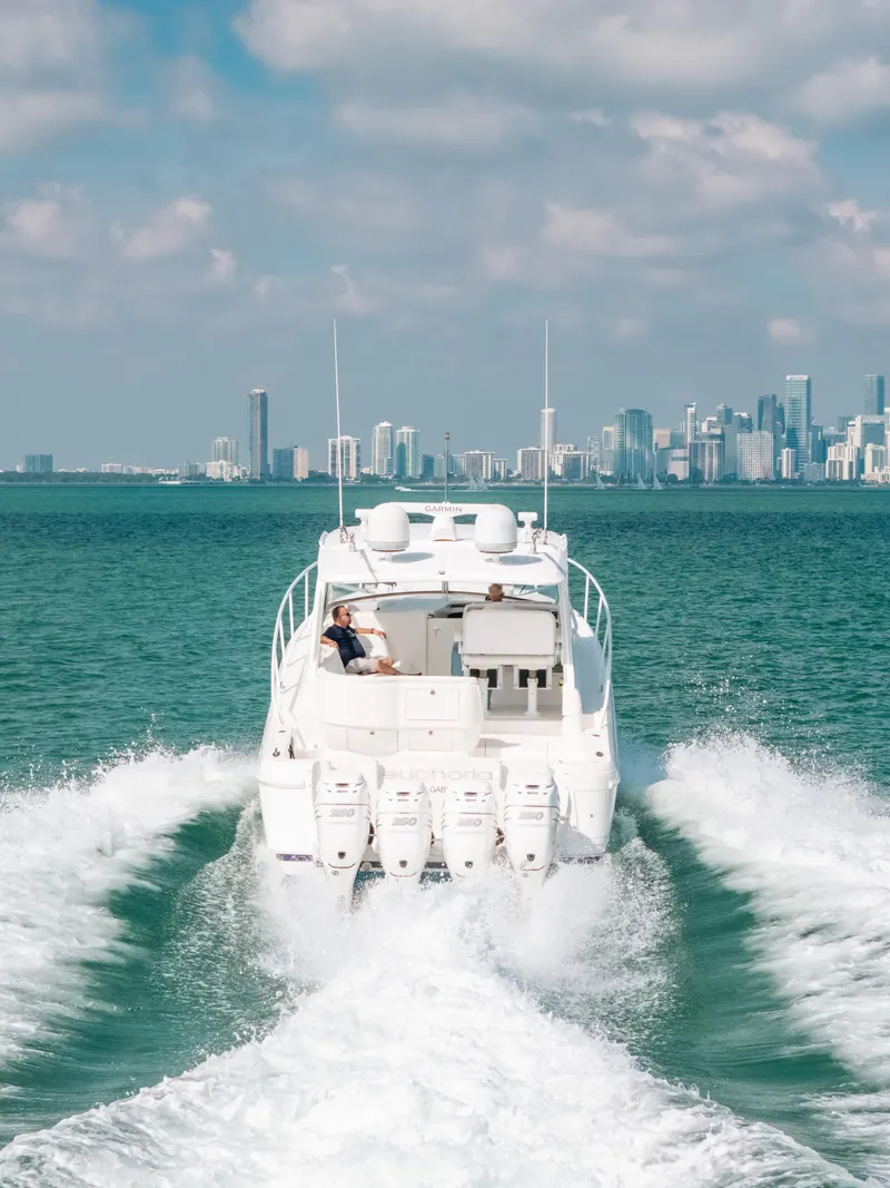 Slide: The Image of 2009 Intrepid 475 Sport Yacht cruising with city skyline in the background. - 13
