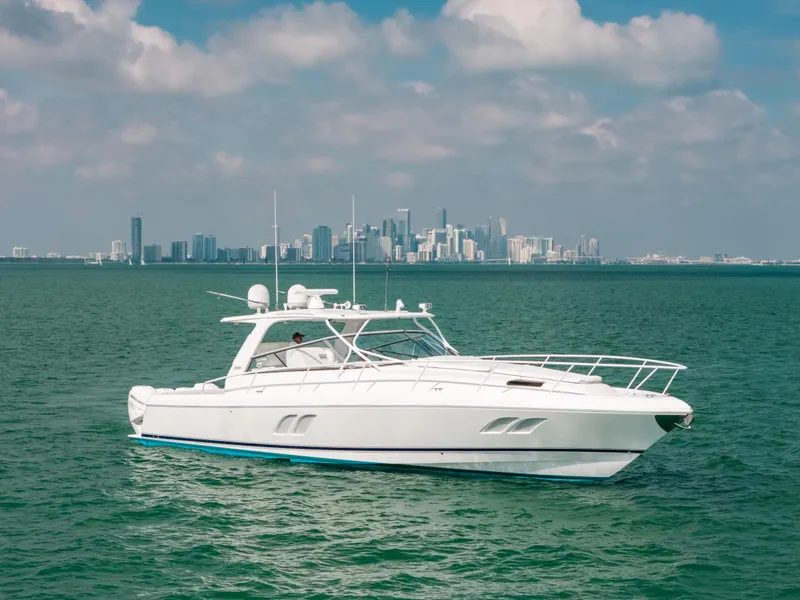 Slide: The Image of 2009 Intrepid 475 Sport Yacht cruising on open water with city skyline backdrop. - 19