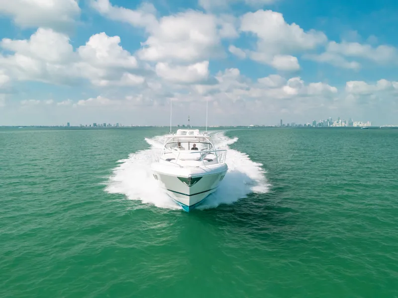 Slide: The Image of 2009 Intrepid 475 Sport Yacht cruising on open water under a partly cloudy sky. - 2