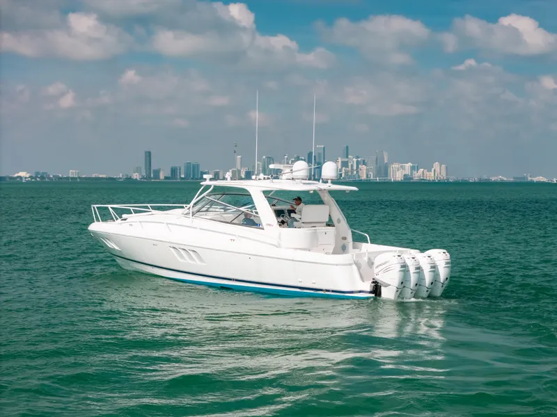 Slide: The Image of 2009 Intrepid 475 Sport Yacht cruising on open water with city skyline backdrop. - 25