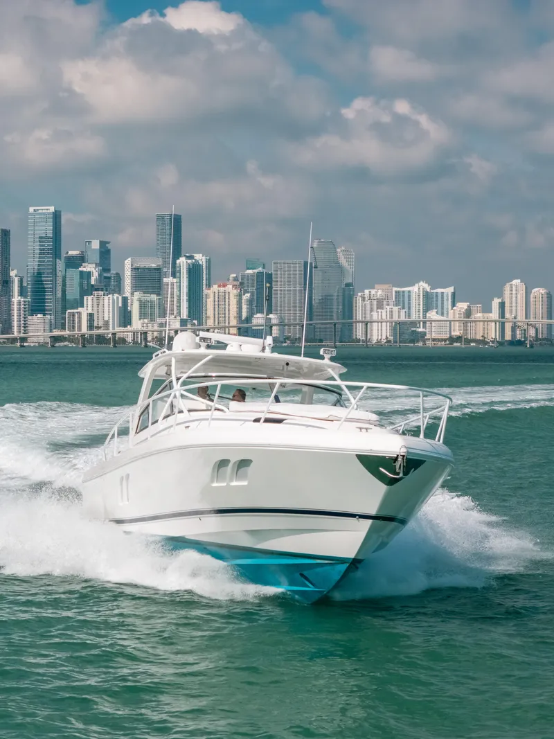 Slide: The Image of 2009 Intrepid 475 Sport Yacht cruising with city skyline in the background. - 3