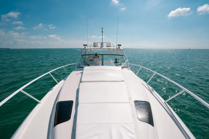 Slide: The Image of 2009 Intrepid 475 Sport Yacht cruising on open sea under clear blue sky. - 30