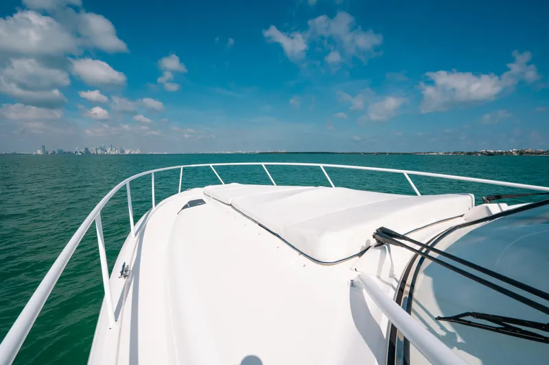 Slide: The Image of 2009 Intrepid 475 Sport Yacht cruising on open water under a clear blue sky. - 31