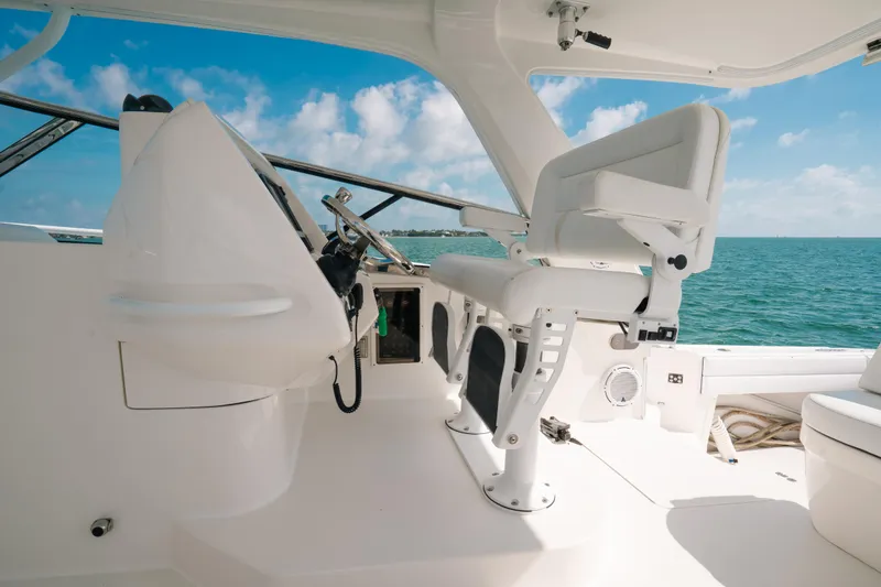 Slide: The Image of 2009 Intrepid 475 Sport Yacht helm with ocean view, featuring modern seating and controls. - 38