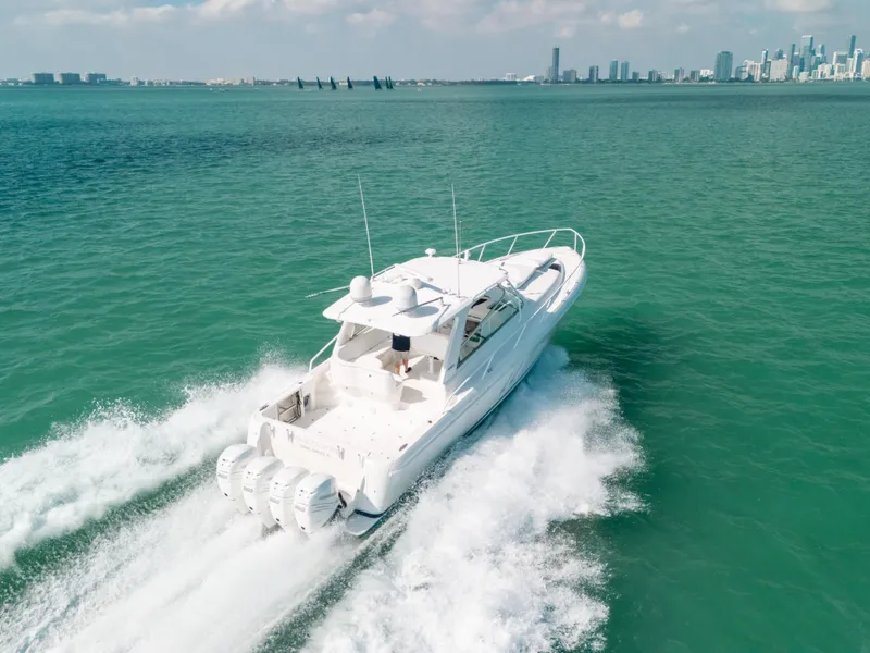 Slide: The Image of 2009 Intrepid 475 Sport Yacht cruising on turquoise waters near a city skyline. - 5