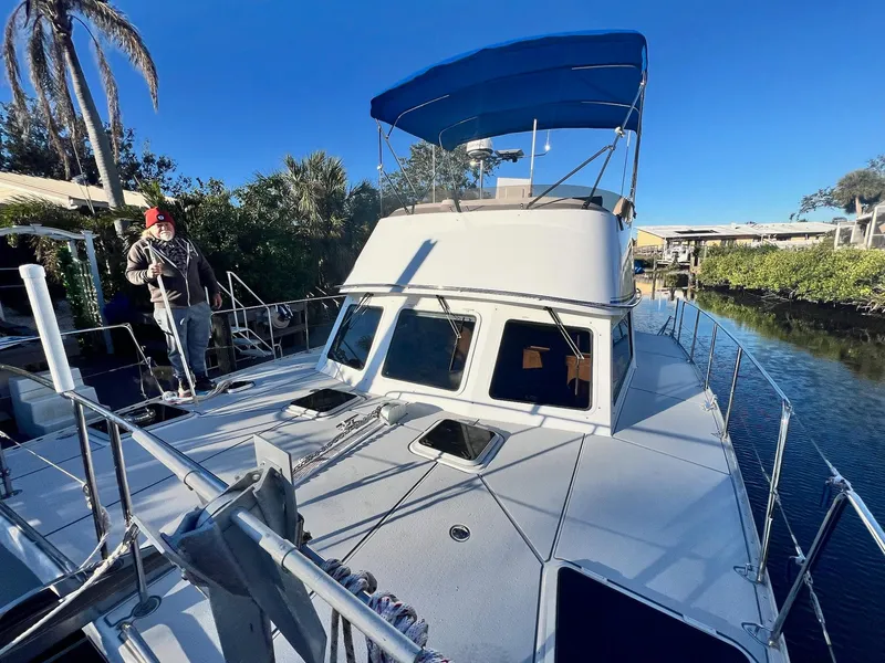 Slide: The Image of 2006 PDQ MV34 boat with blue canopy docked in a scenic canal setting. - 11