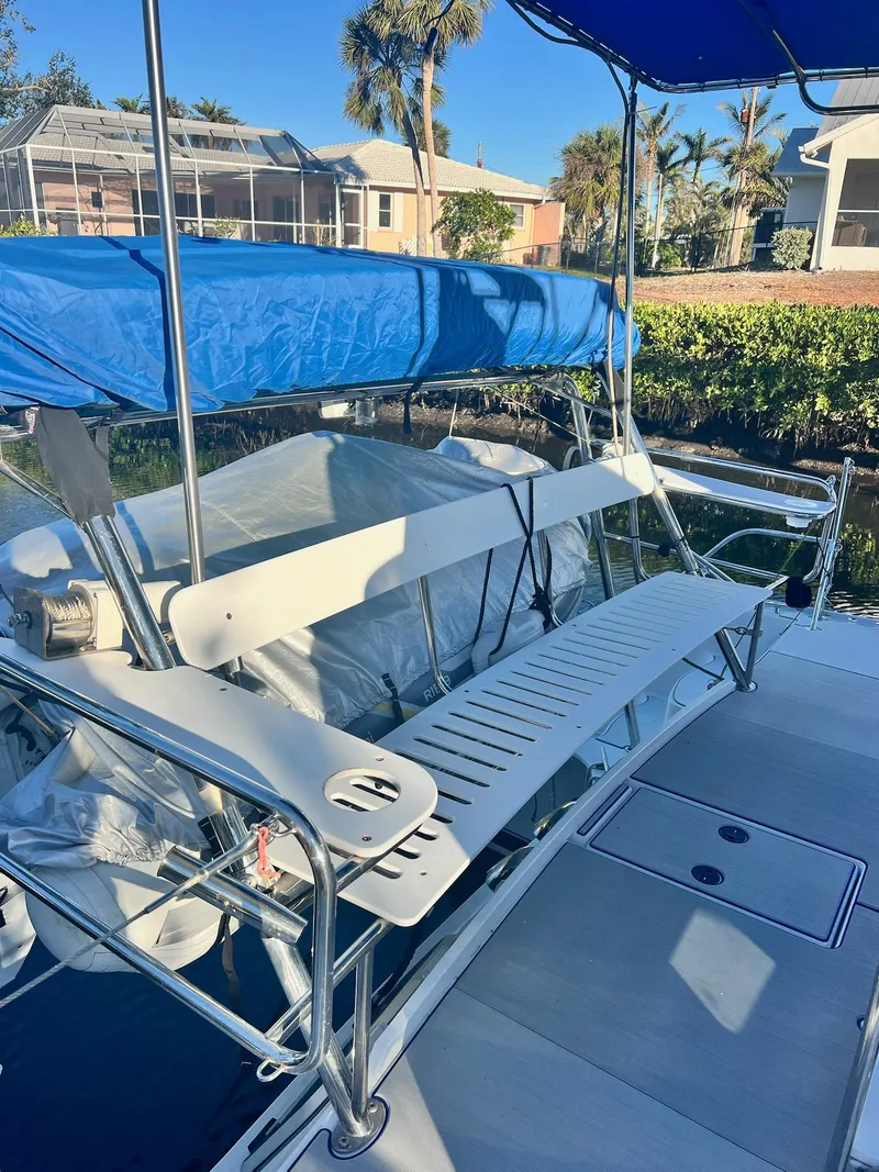 Slide: The Image of 2006 PDQ MV34 boat with blue canopy, docked near waterfront homes. - 13