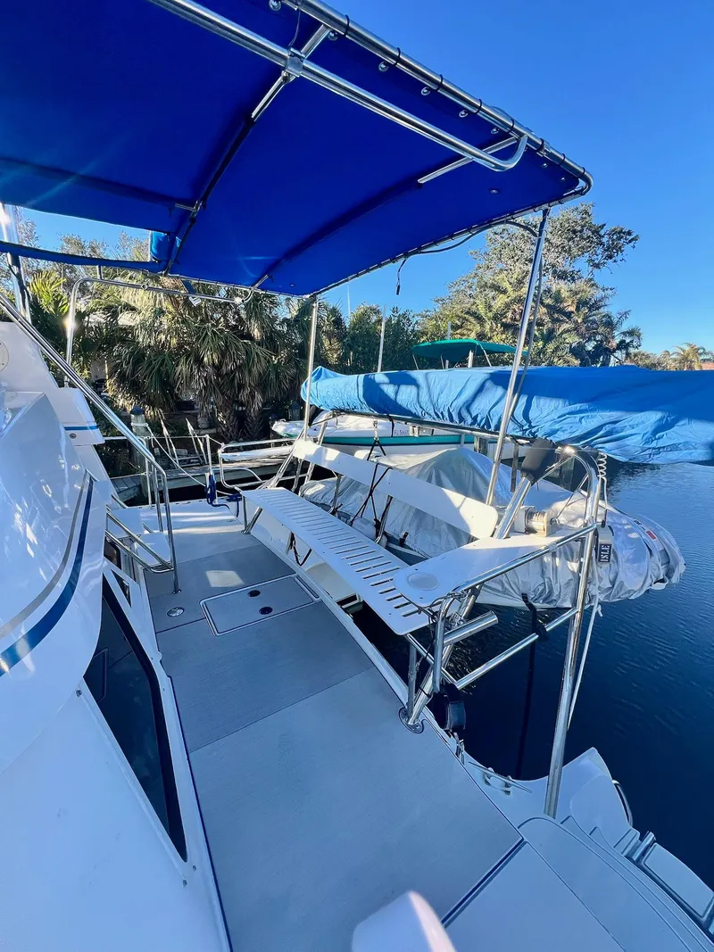 Slide: The Image of 2006 PDQ MV34 boat deck with blue canopy and seating, docked by water. - 17