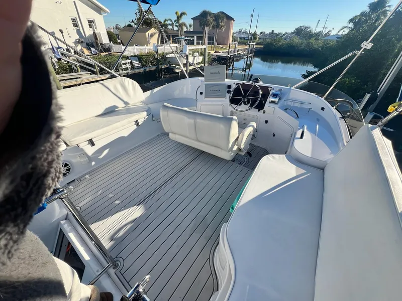 Slide: The Image of 2006 PDQ MV34 boat interior with white seating and steering wheel, docked by a canal. - 24