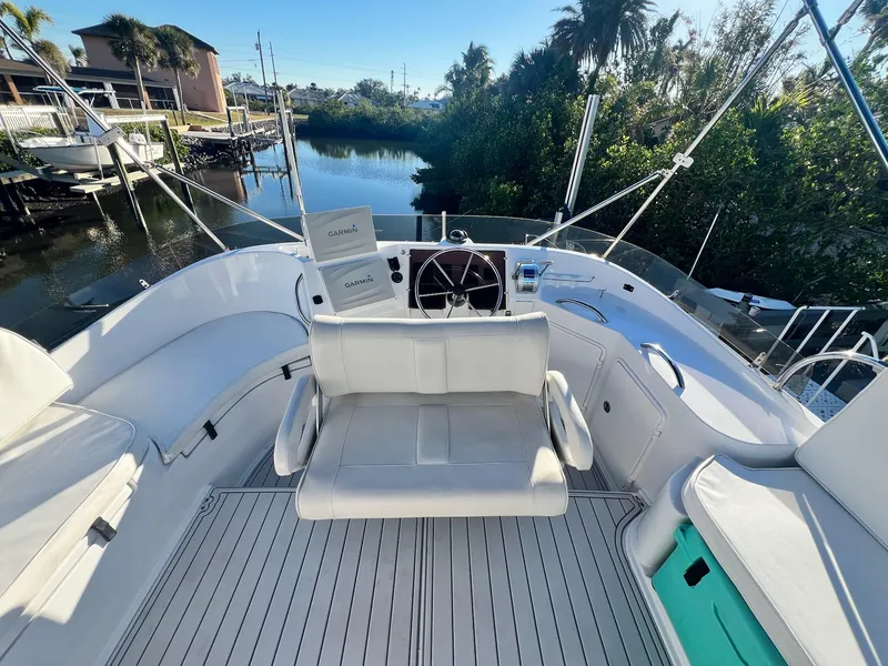 Slide: The Image of 2006 PDQ MV34 boat deck with seating, steering wheel, and scenic waterfront view. - 29
