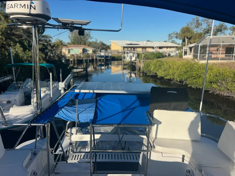 Slide: The Image of 2006 PDQ MV34 boat docked in a serene canal setting with clear blue skies. - 37