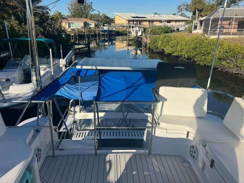 Slide: The Image of 2006 PDQ MV34 boat docked in a serene canal setting with blue canopy. - 38