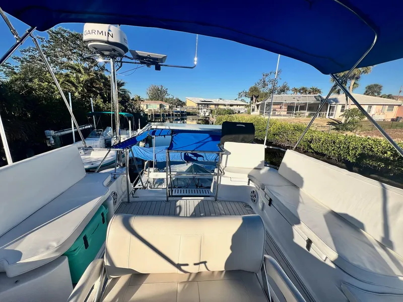 Slide: The Image of 2006 PDQ MV34 boat with spacious seating and canopy, docked in a sunny marina. - 40