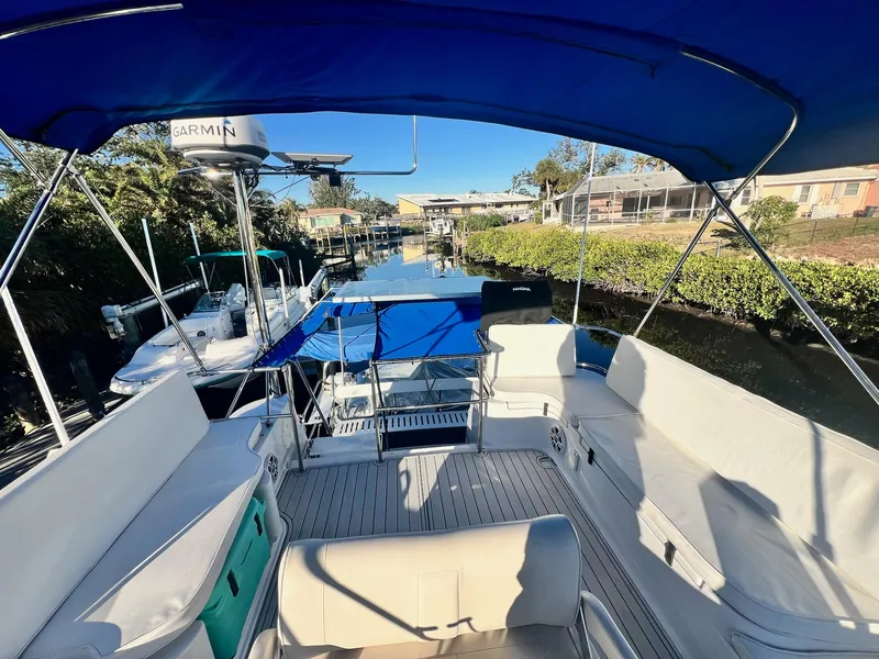 Slide: The Image of PDQ MV34 2006 boat with blue canopy, docked in a sunny marina. - 41