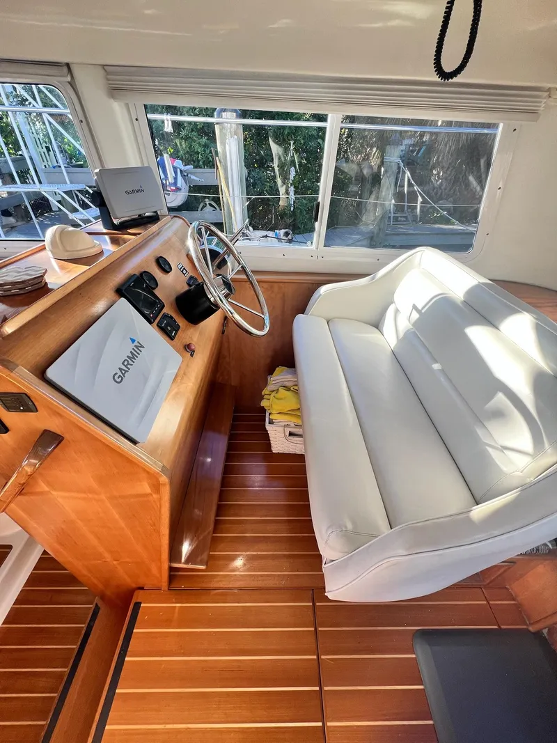Slide: The Image of Interior of 2006 PDQ MV34 boat with wooden flooring and white seating. - 44