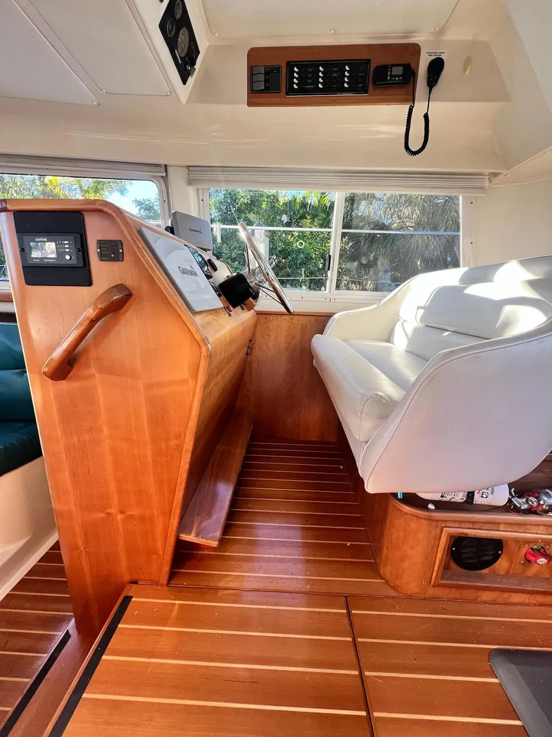 Slide: The Image of 2006 PDQ MV34 boat interior with wooden helm and white seating. - 45
