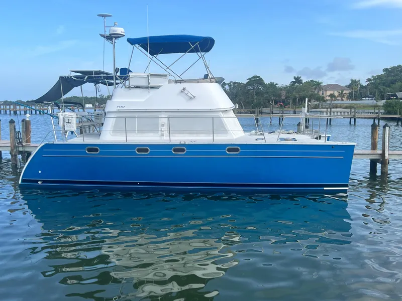 Slide: The Image of Blue PDQ MV34 boat docked on calm water, 2006 model. - 48