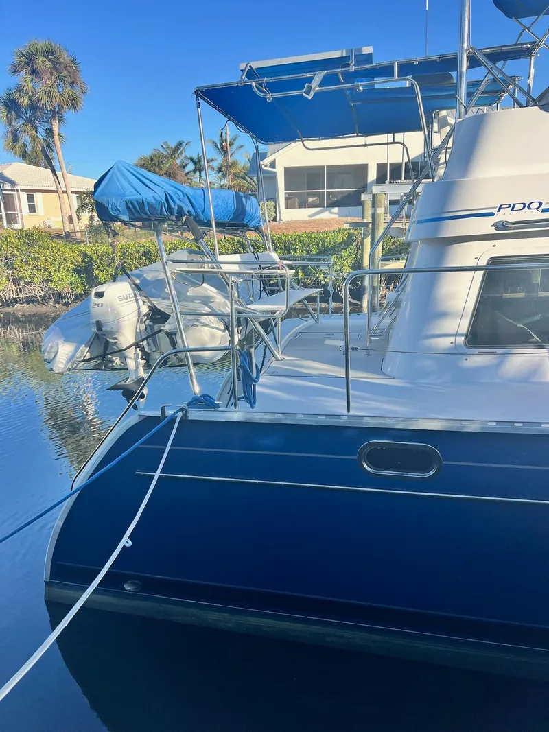 Slide: The Image of 2006 PDQ MV34 boat docked, featuring blue and white design with canopy and motor. - 5