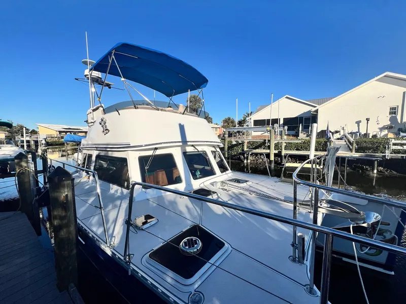 Slide: The Image of PDQ MV34 2006 boat docked, featuring a blue canopy and sleek design. - 9