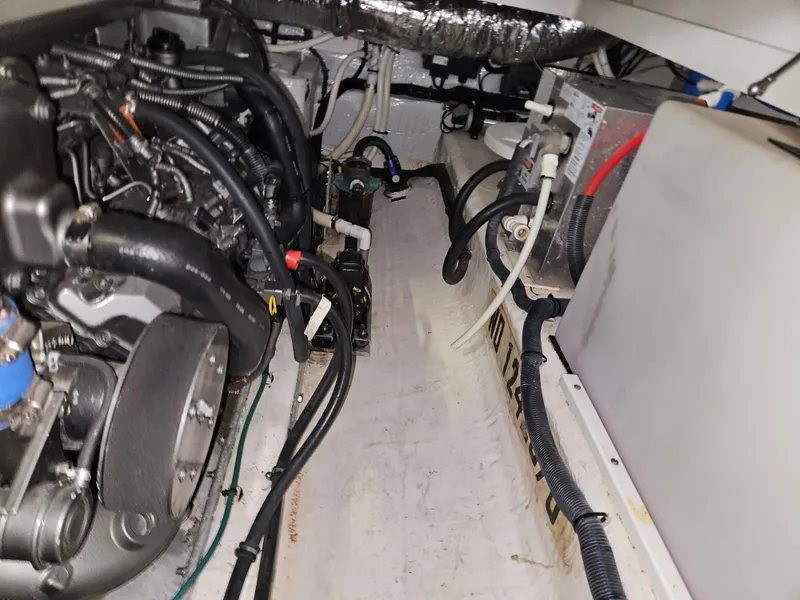 Slide: The Image of Engine compartment of a 2012 Back Cove 30 boat, showcasing mechanical components and wiring. - 12