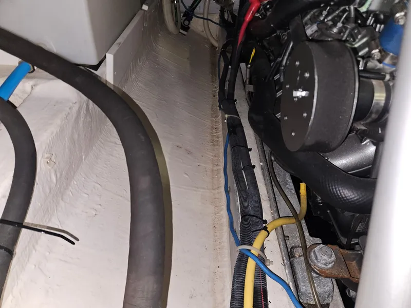 Slide: The Image of Engine compartment of a 2012 Back Cove 30 boat, showing hoses and wiring. - 13