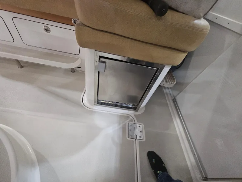 Slide: The Image of 2012 Back Cove 30 interior with compact fridge and seating area. - 16