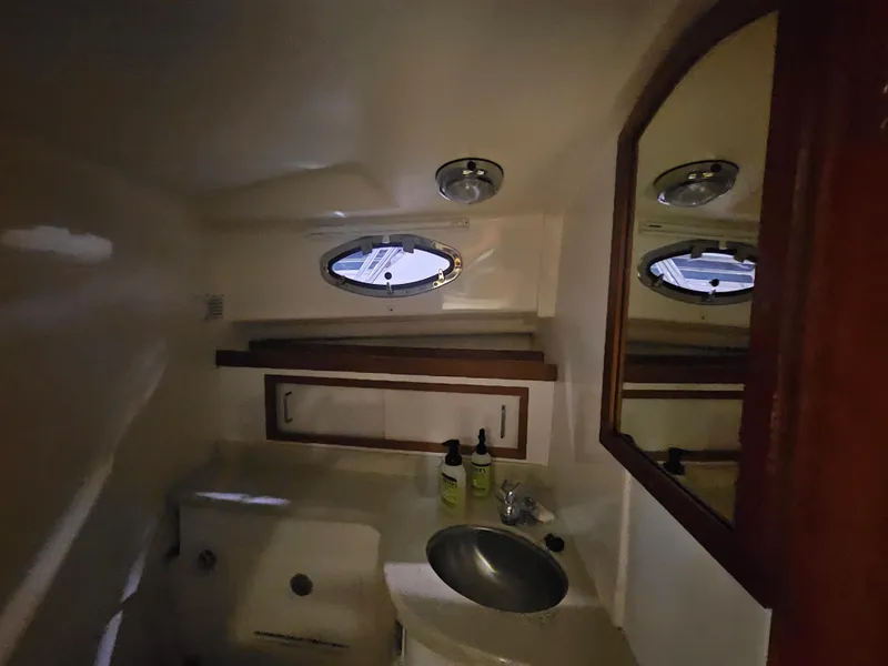 Slide: The Image of Interior of 2012 Back Cove 30 boat bathroom with sink, mirror, and porthole window. - 17