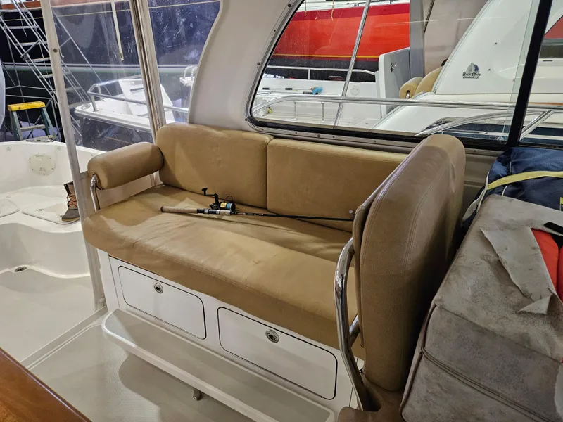 Slide: The Image of Interior seating of a 2012 Back Cove 30 boat with fishing rod on beige cushions. - 21