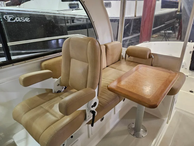 Slide: The Image of Interior of a 2012 Back Cove 30 boat with beige seating and wooden table. - 23