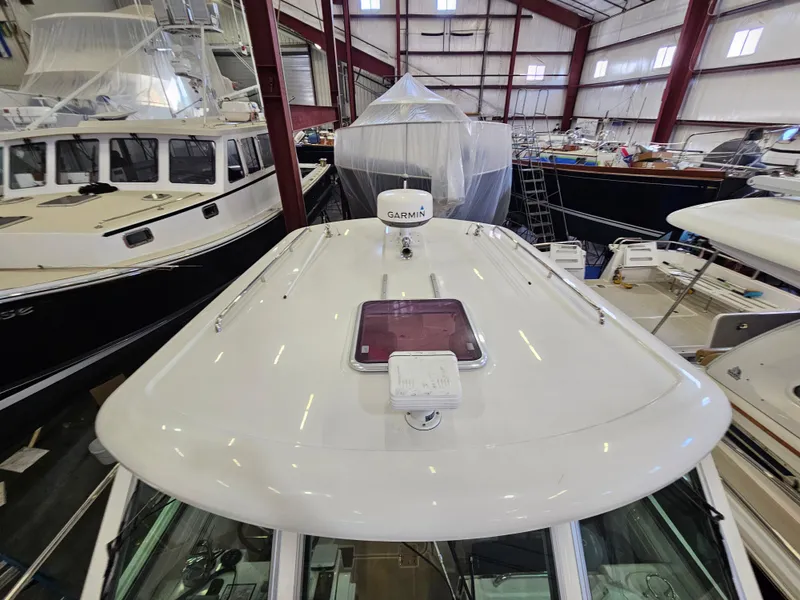 Slide: The Image of 2012 Back Cove 30 boat in storage, featuring a sleek white deck and Garmin equipment. - 27