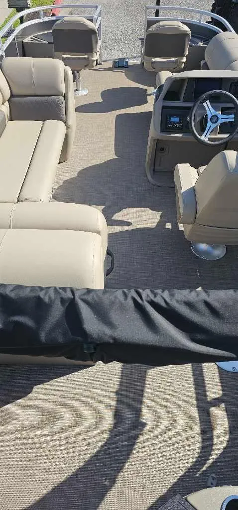 Slide: The Image of 2024 Sun Tracker Fishin' Barge 20 DLX interior with beige seating and steering console. - 4