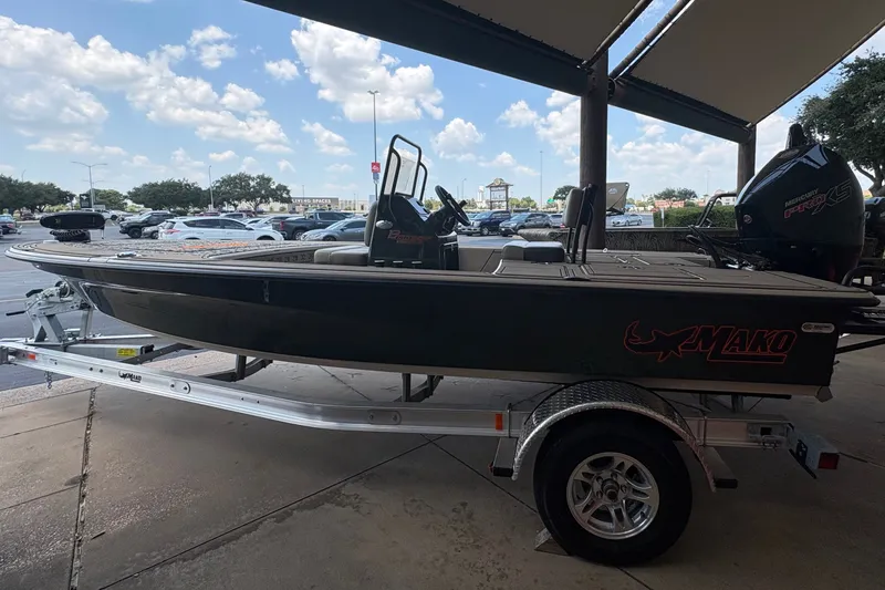 Slide: The Image of A 2025 Mako 18 Pro Skiff Backwater Edition on a trailer under a canopy. - 7