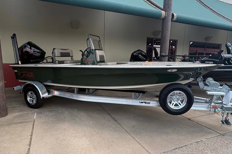 Slide: The Image of A 2025 Mako 18 Pro Skiff Backwater Edition on a trailer, featuring a green hull and outboard motor. - 3